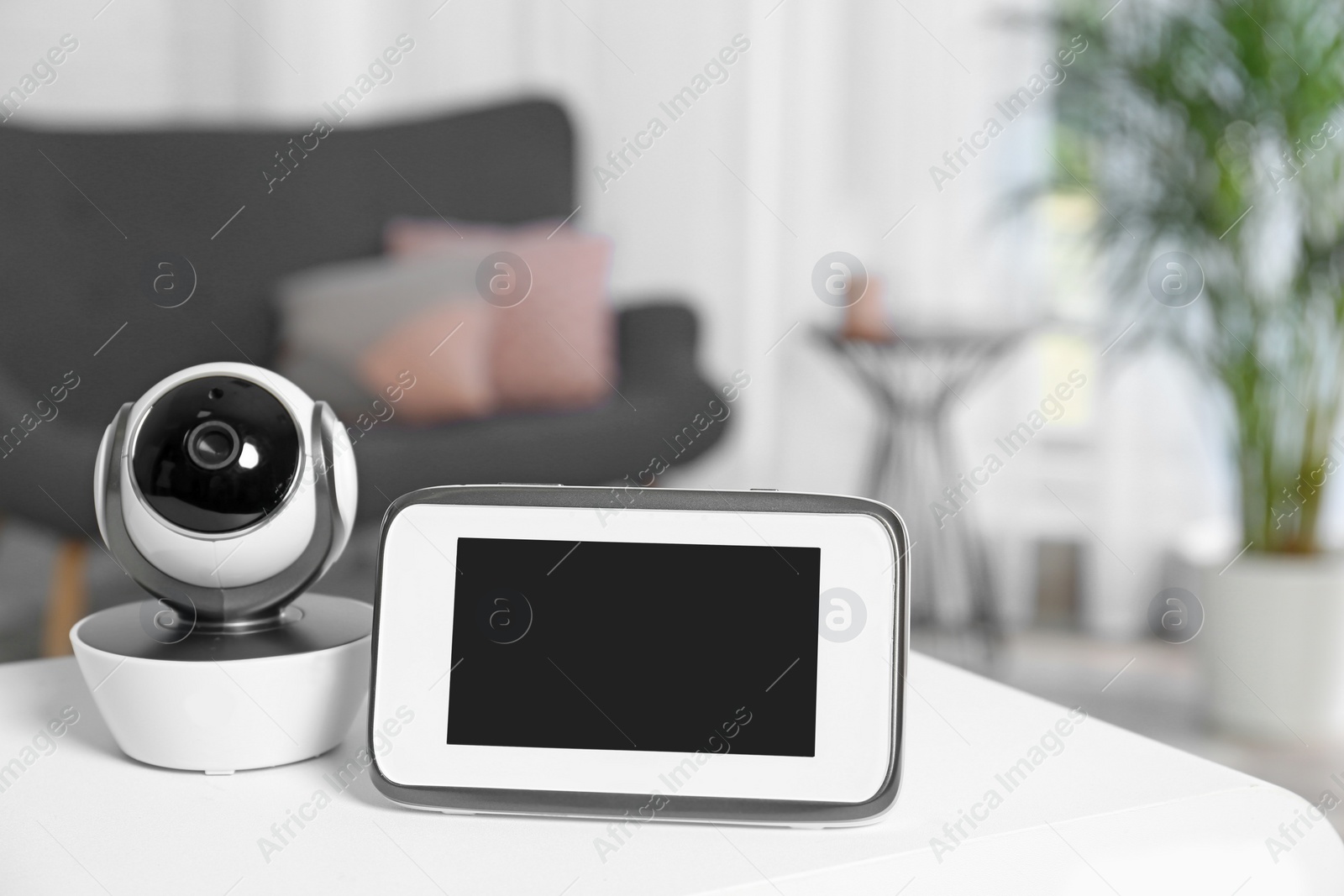 Photo of Baby monitor and camera on table in living room. Video nanny