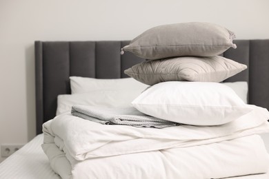 Photo of Soft pillows and bedding set on bed at home