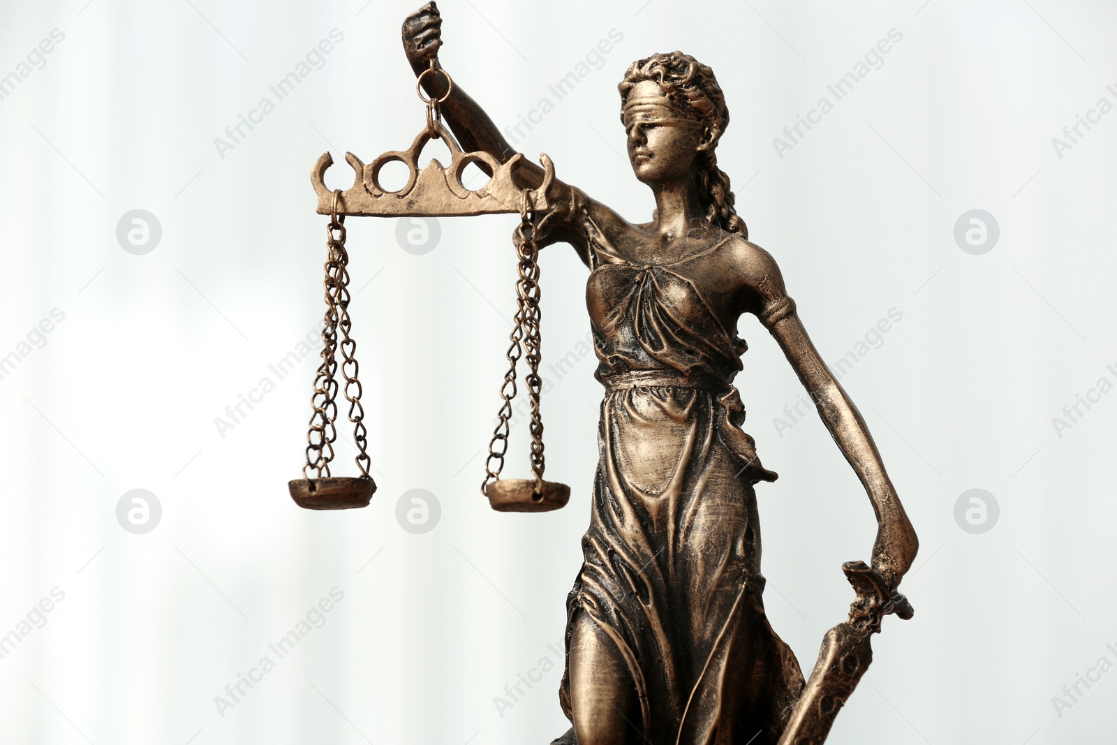 Photo of Symbol of fair treatment under law. Figure of Lady Justice on white background, closeup