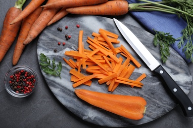 Flat lay composition with raw carrots on grey table