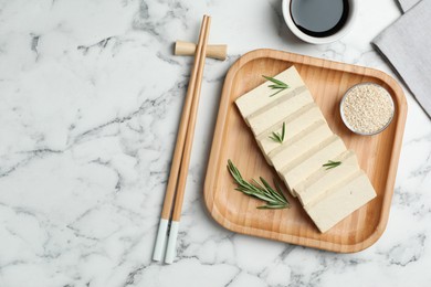 Photo of Delicious tofu with rosemary served on white marble table, flat lay. Space for text