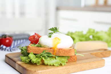 Delicious poached egg sandwich served on wooden board