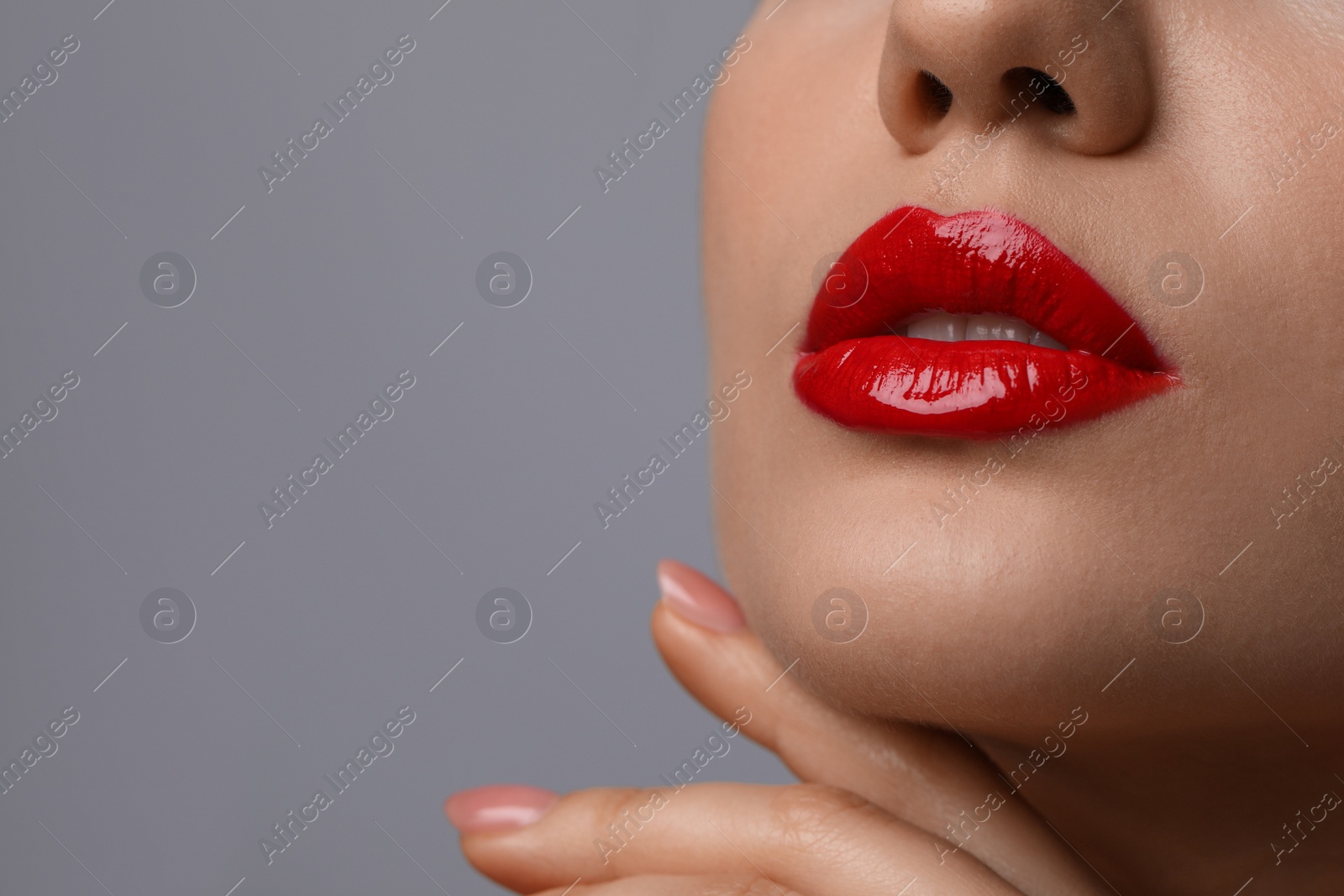 Photo of Closeup view of woman with beautiful full lips on grey background. Space for text