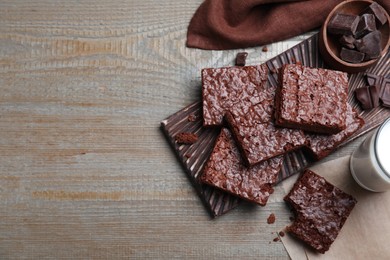 Photo of Delicious chocolate brownies on wooden table, flat lay. Space for text