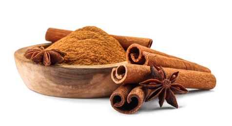 Photo of Dry aromatic cinnamon sticks. powder and anise stars isolated on white