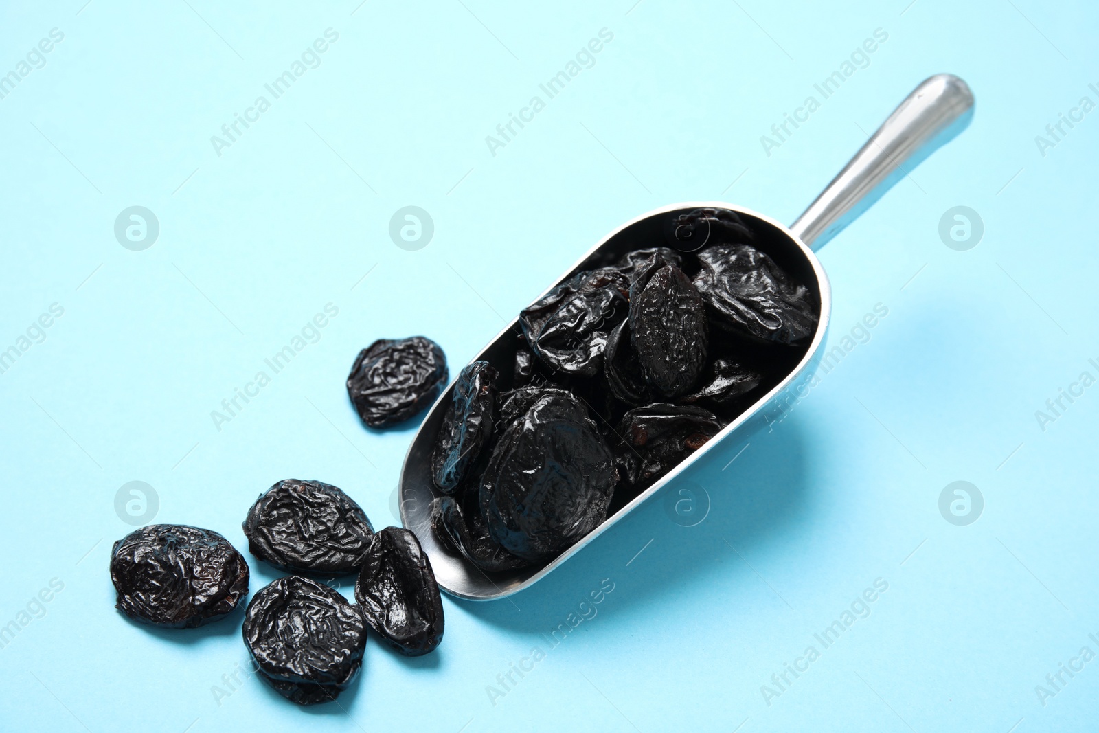 Photo of Scoop of dried plums on color background. Healthy fruit