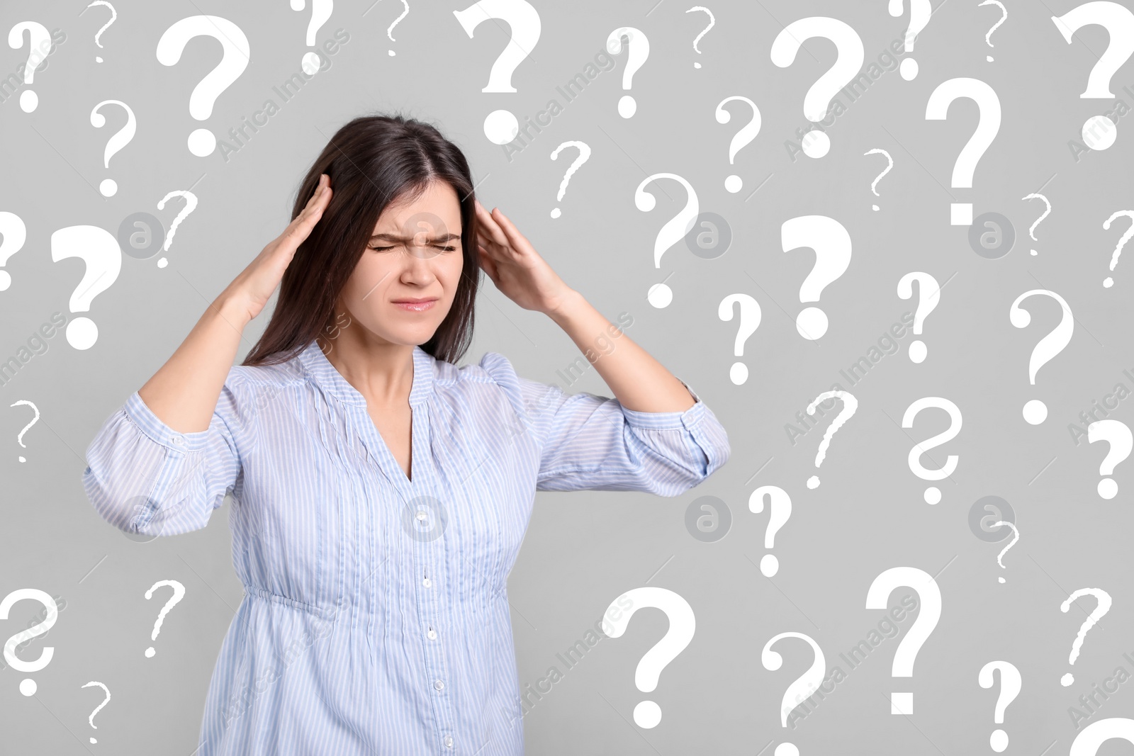 Image of Amnesia. Confused young woman and question marks on light grey background