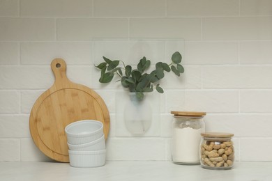 Photo of Silicone vase with eucalyptus branches on wall over countertop in kitchen