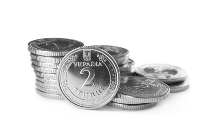 Photo of Stacks of Ukrainian coins on white background. National currency