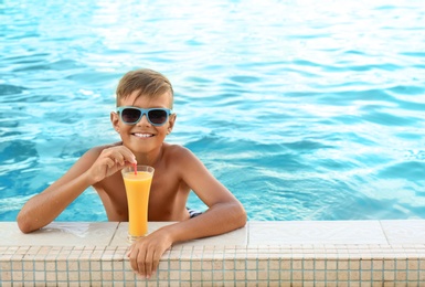 Photo of Happy cute boy with drink in swimming pool