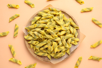 Photo of Garganelli pasta on light orange background, flat lay