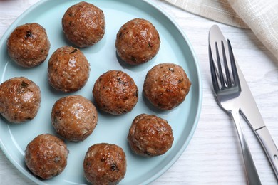 Photo of Tasty cooked meatballs served on white wooden table, flat lay