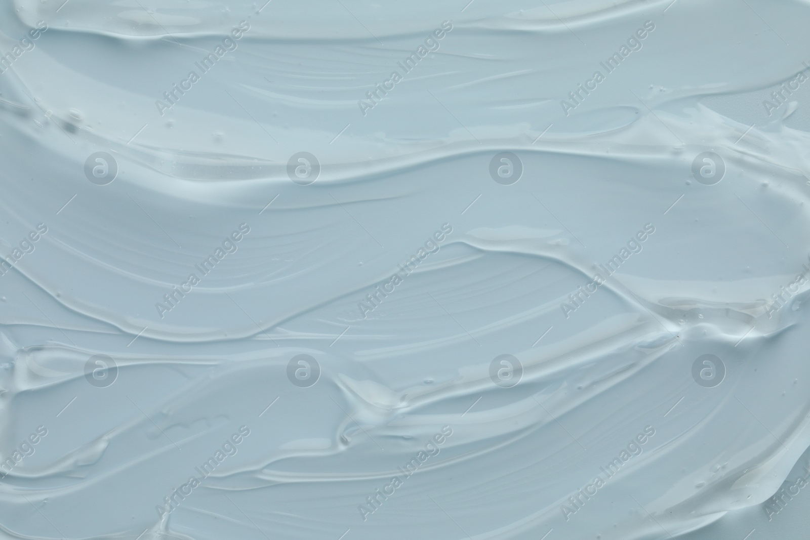 Photo of Clear cosmetic gel on light blue background, top view
