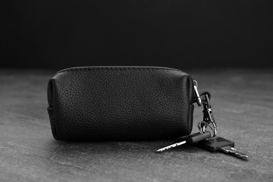 Photo of Leather case with keys on grey table, closeup