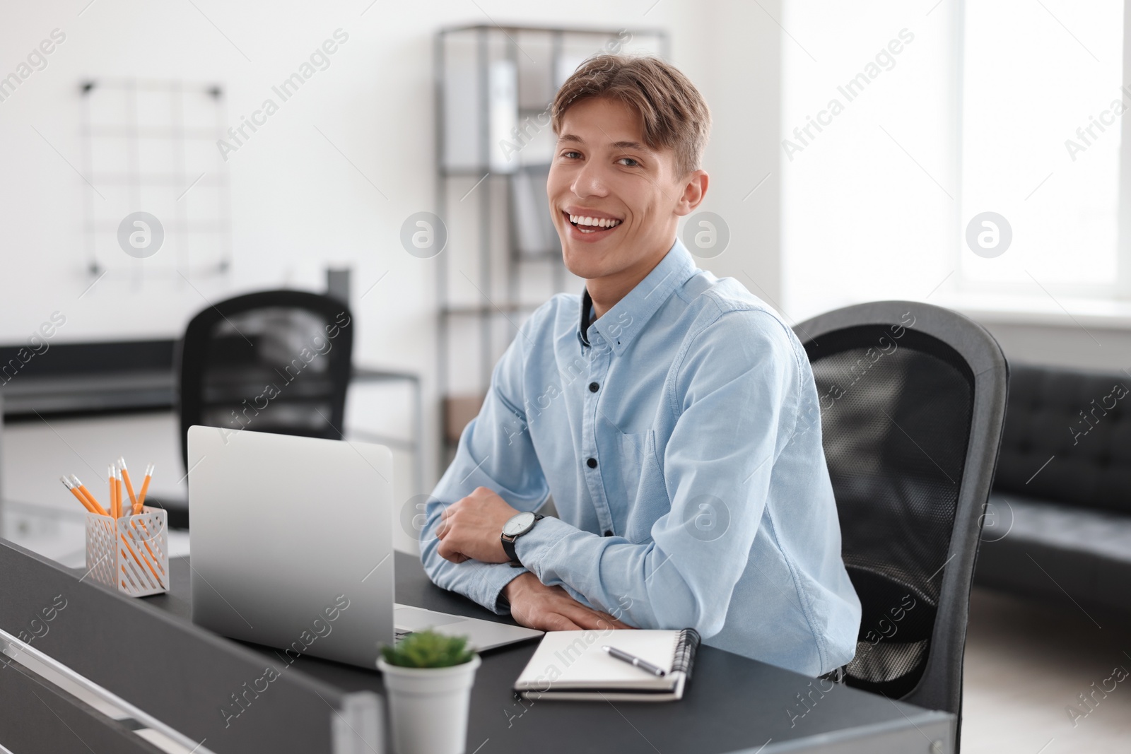 Photo of Man watching webinar at table in office