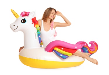 Beautiful young woman in stylish bikini with  unicorn inflatable ring on white background