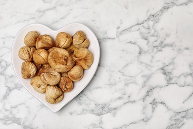 Photo of Plate of figs on marble background, top view with space for text. Dried fruit as healthy food