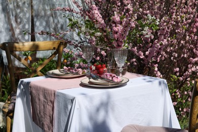 Photo of Stylish table setting with beautiful spring flowers in garden