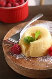 Tasty vanilla fondant with white chocolate and raspberries on table, closeup