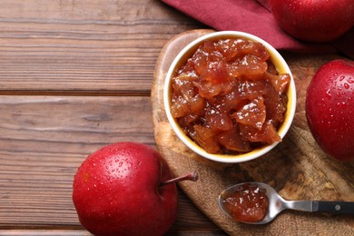 Photo of Delicious apple jam and fresh fruits on wooden table, flat lay. Space for text