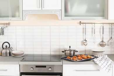 Stylish kitchen interior with modern oven and set of cooking utensils