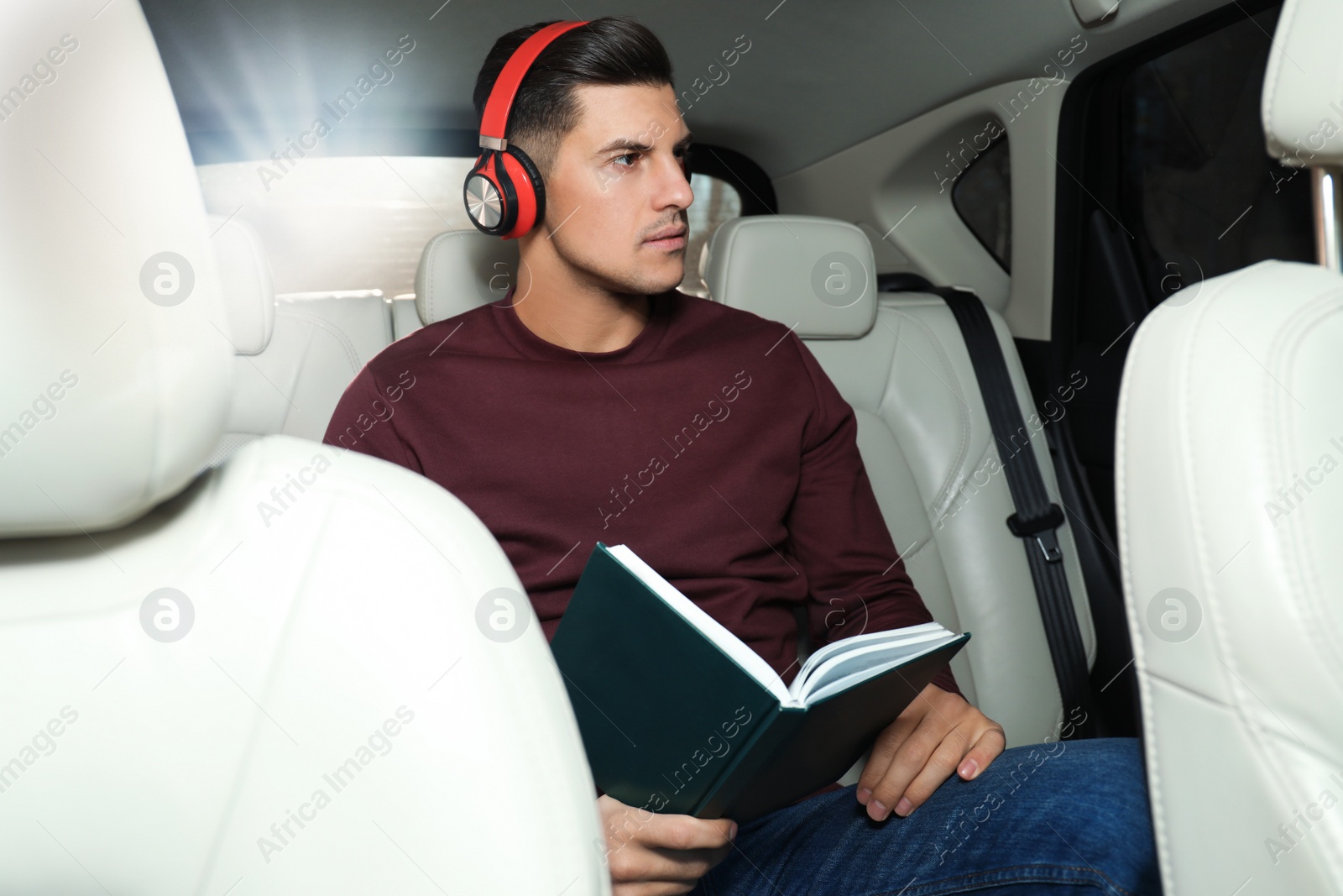 Photo of Handsome man listening to audiobook in car