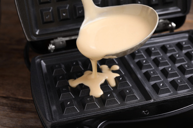Pouring dough onto Belgian waffle maker, closeup