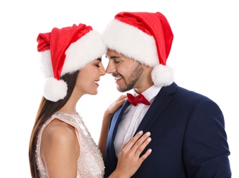 Photo of Lovely young couple in Santa hats on white background. Christmas celebration