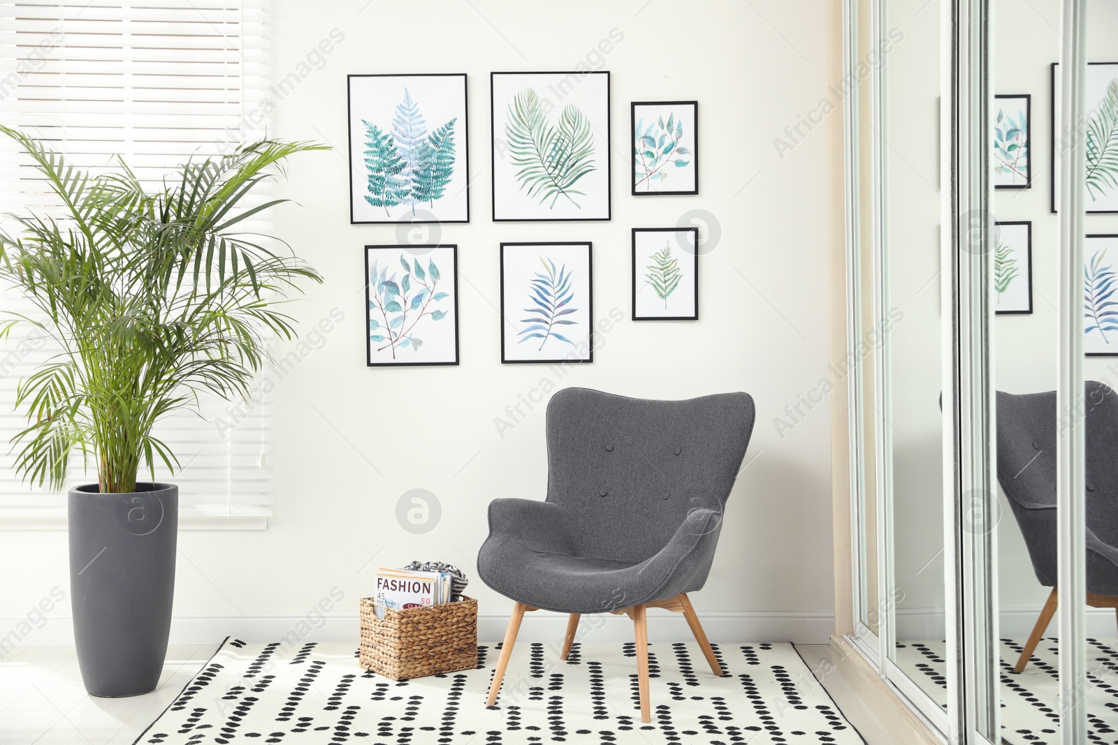 Photo of Beautiful paintings of tropical leaves on white wall in room interior
