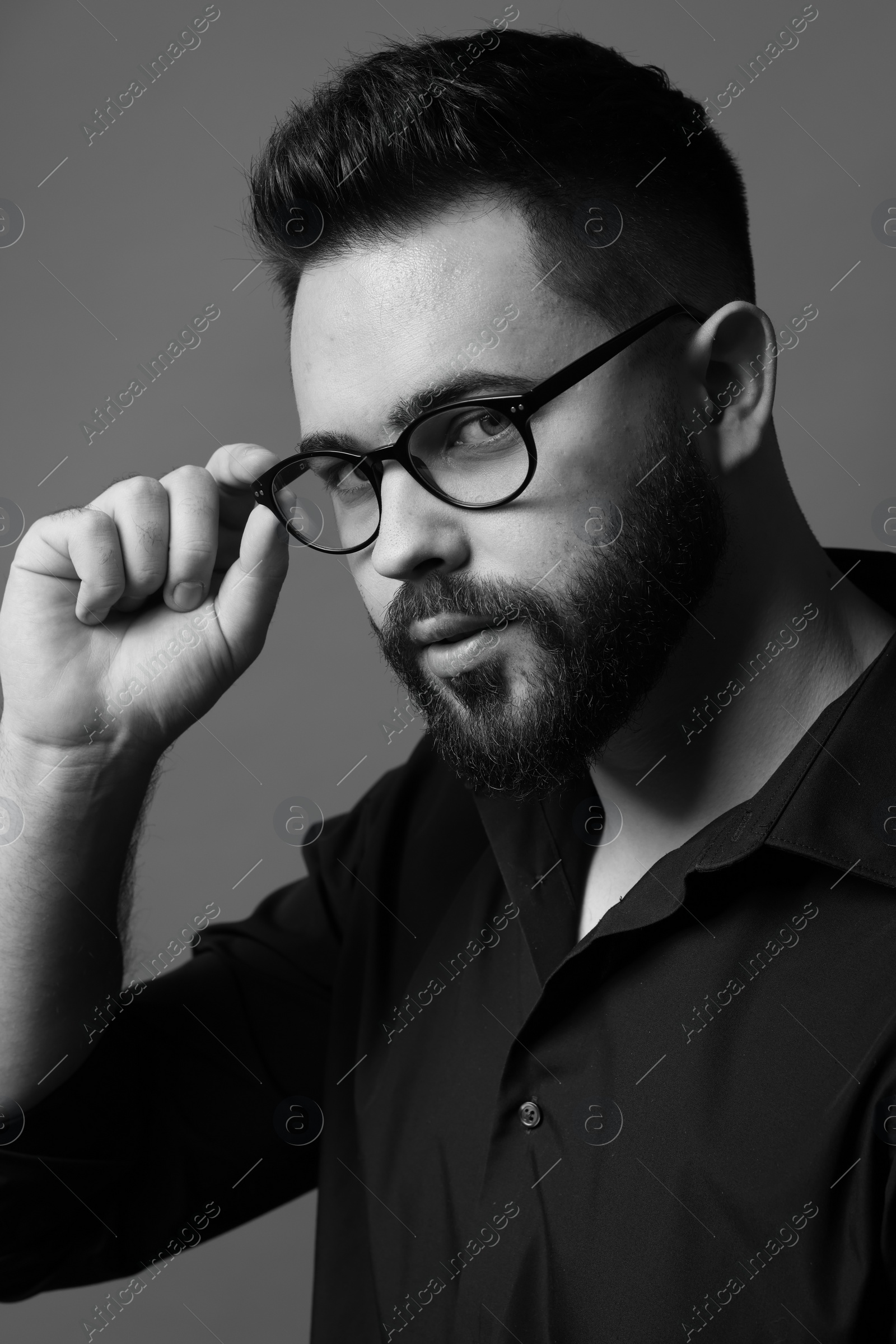 Photo of Portrait of handsome bearded man on grey background. Black and white effect