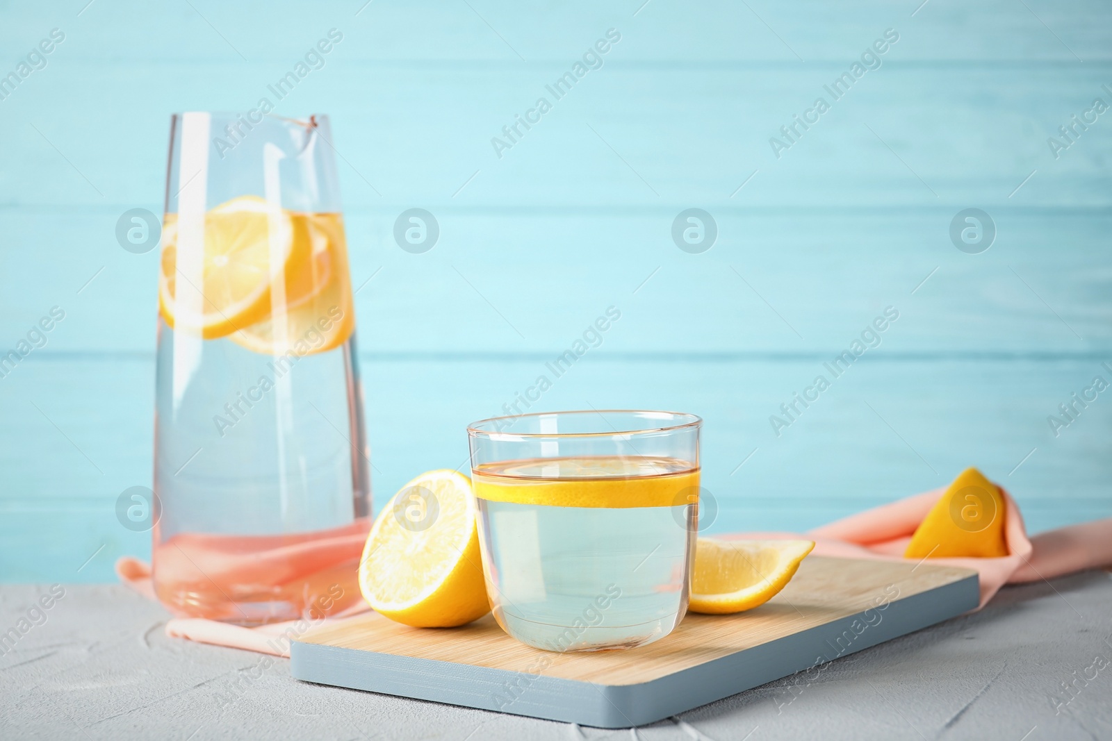 Photo of Glass of water with lemon slice on wooden board