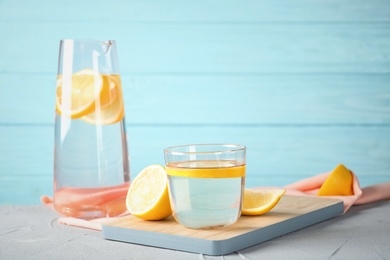 Glass of water with lemon slice on wooden board