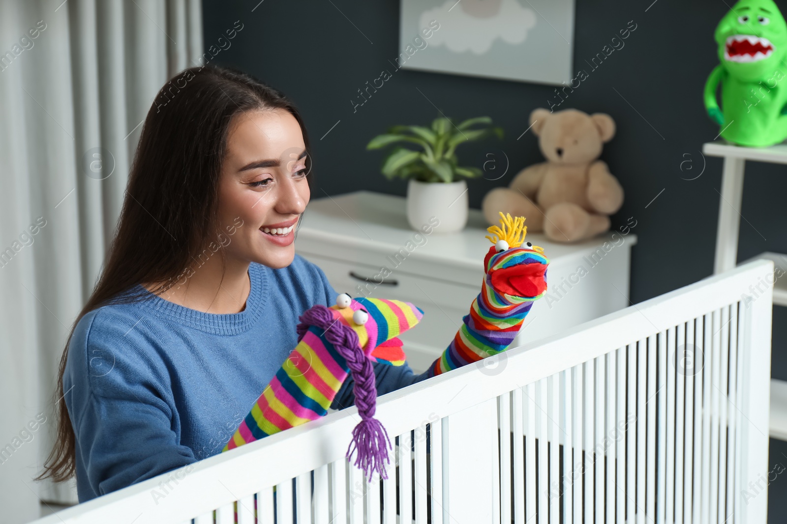 Photo of Young woman performing puppet show at home