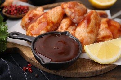 Fresh marinade, raw chicken wings and lemon on table, closeup