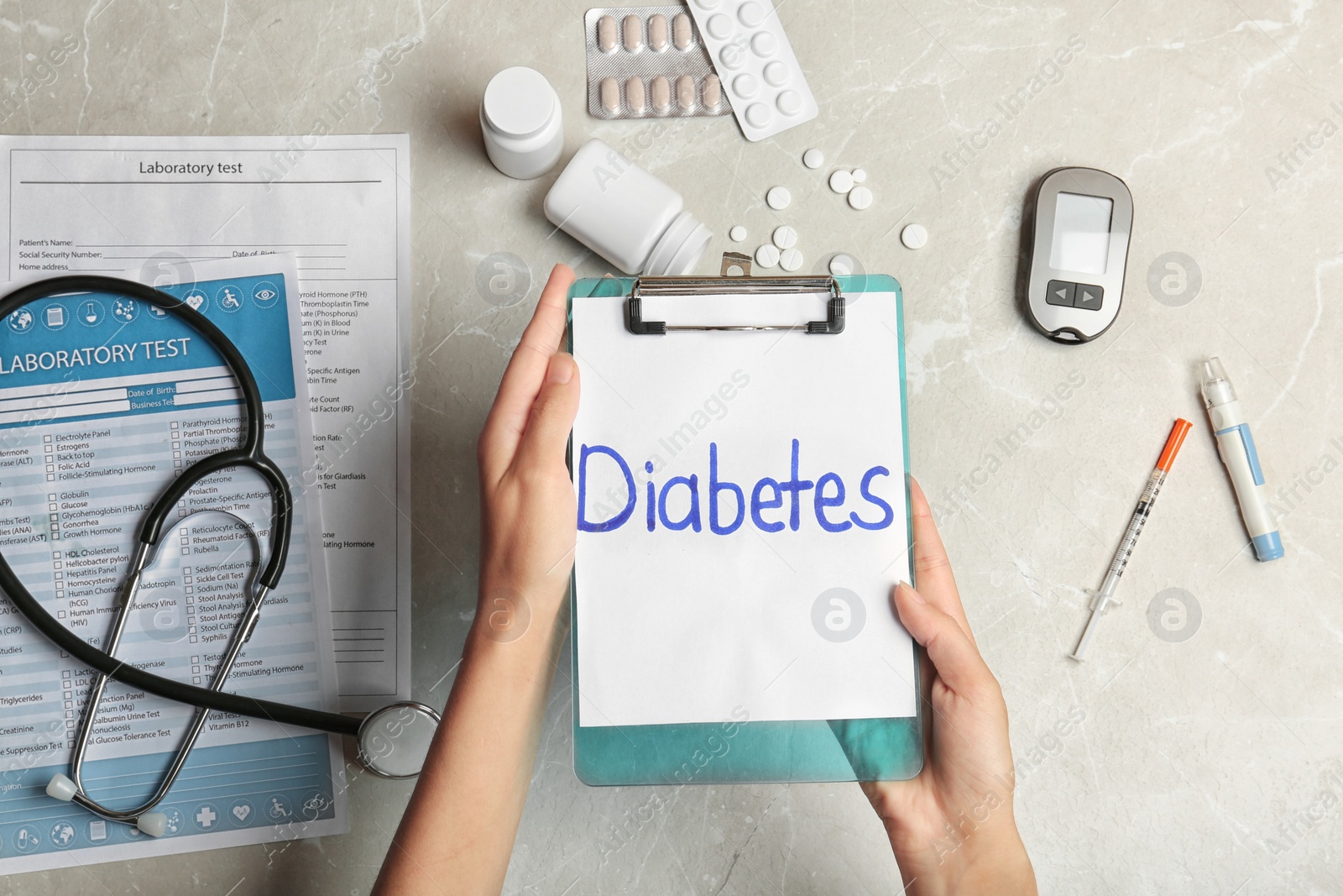 Photo of Woman holding clipboard with word DIABETES over table, top view