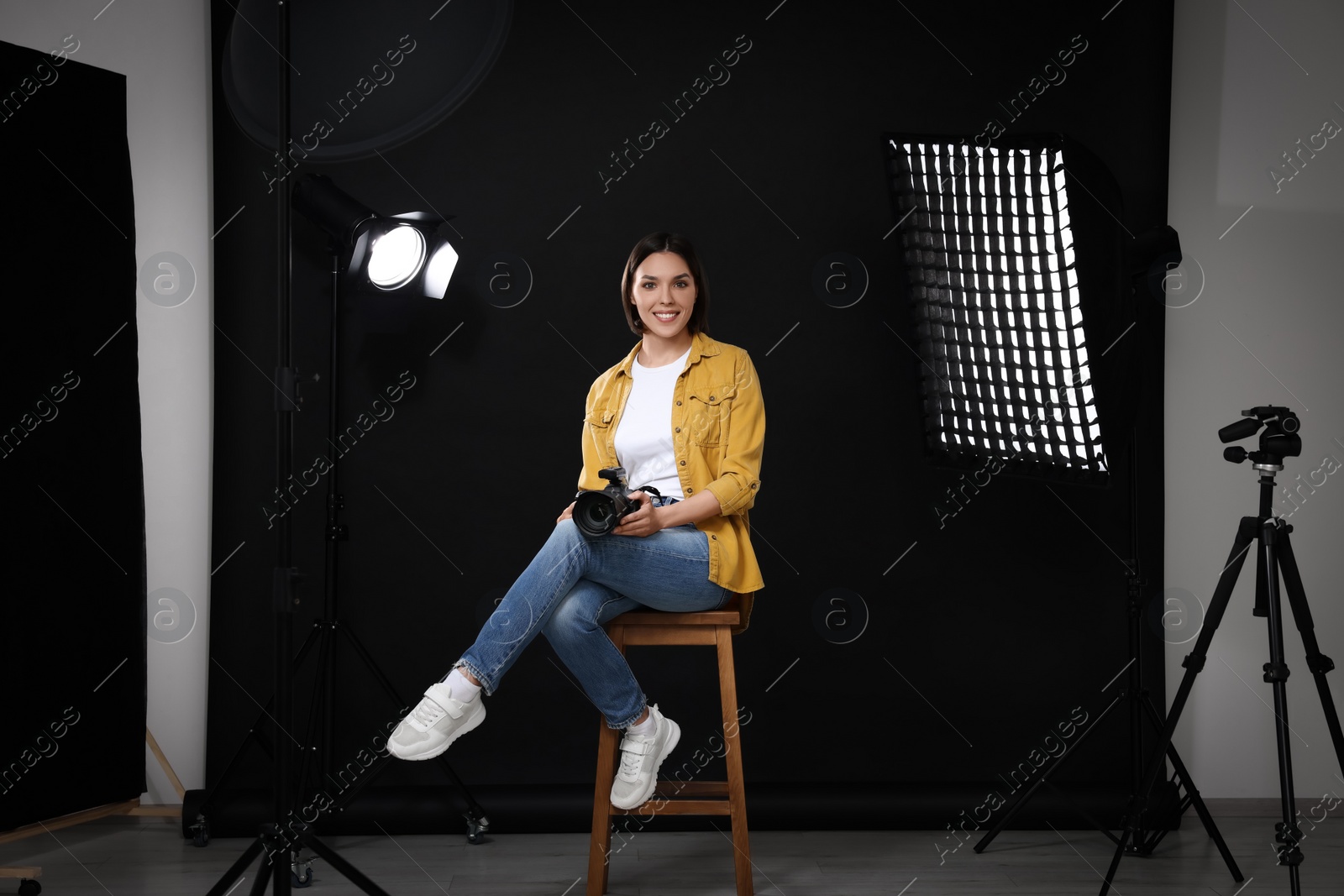 Photo of Professional photographer with camera in modern photo studio