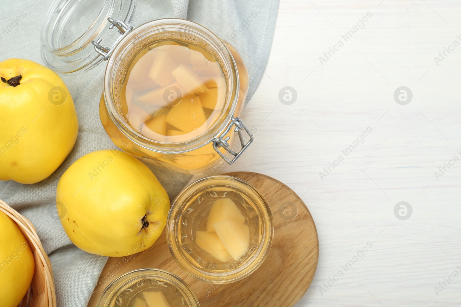 Photo of Delicious quince drink and fresh fruits on white wooden table, top view. Space for text