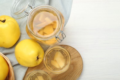 Photo of Delicious quince drink and fresh fruits on white wooden table, top view. Space for text