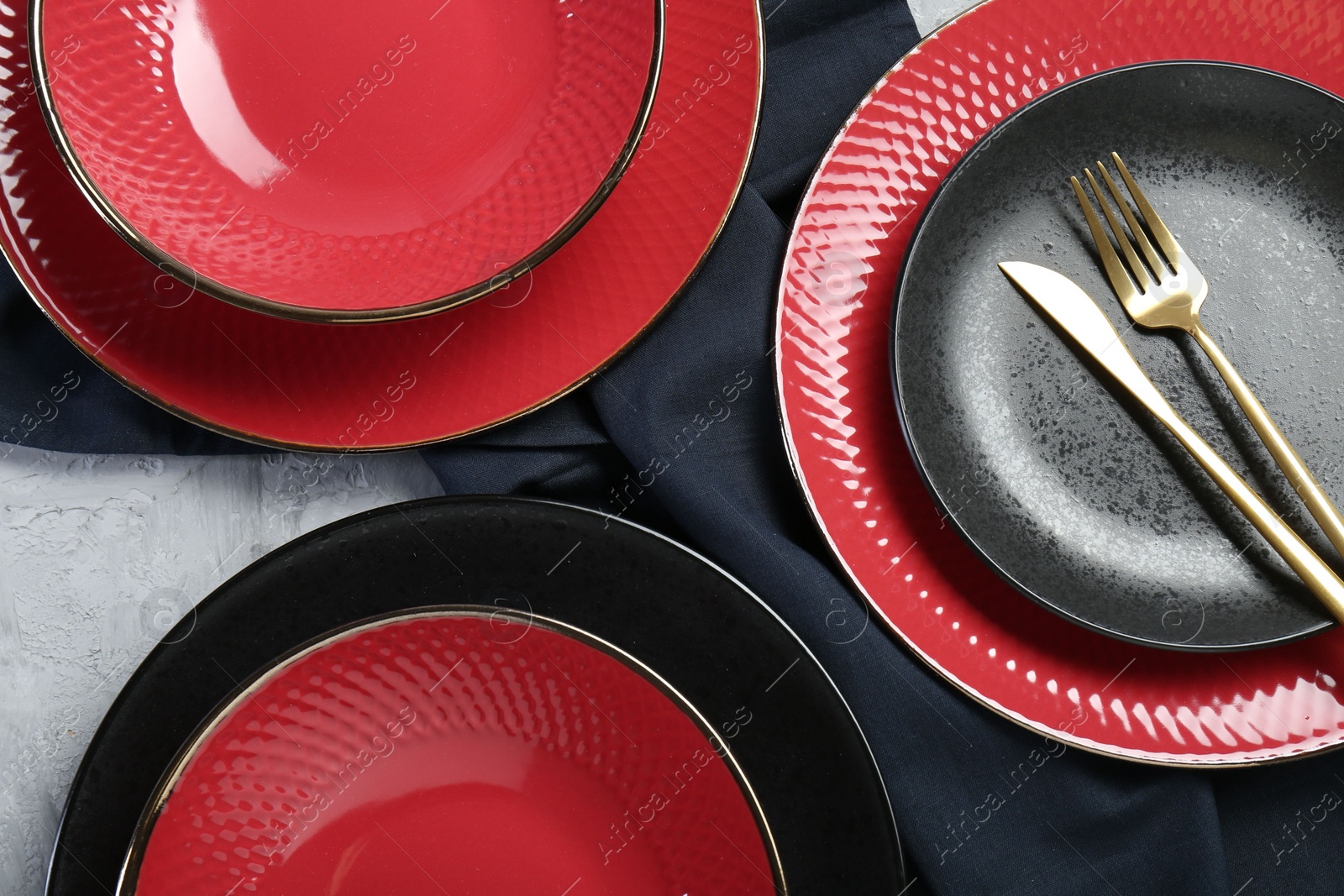 Photo of Stylish ceramic plates and cutlery on light table, flat lay