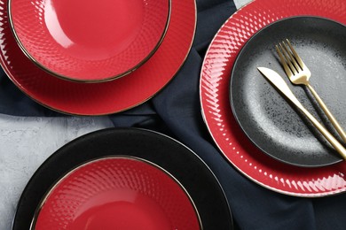 Stylish ceramic plates and cutlery on light table, flat lay
