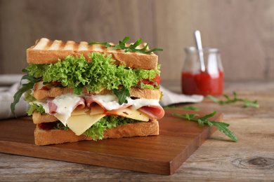 Photo of Yummy sandwich with ham served on wooden table