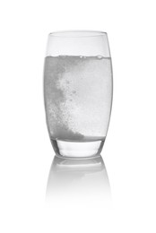 Effervescent pill dissolving in glass of water isolated on white