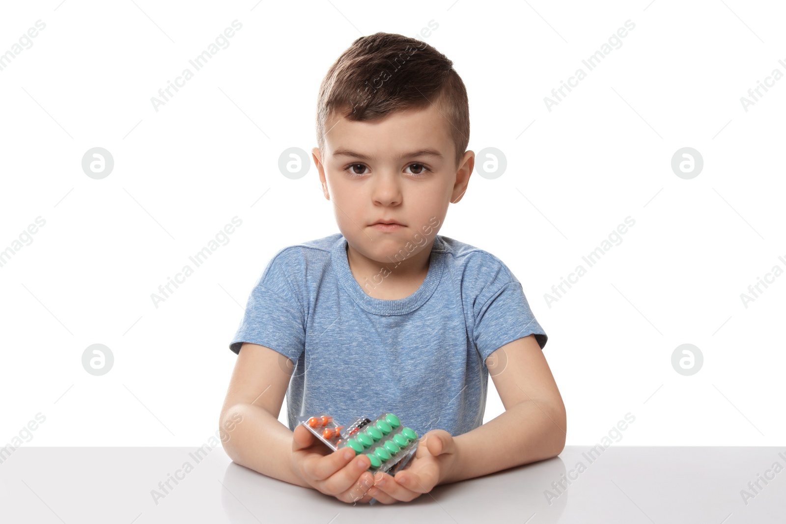 Photo of Little child with different pills on white background. Household danger