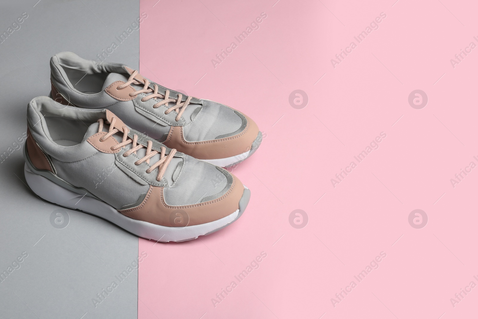 Photo of Pair of sports shoes on color background. Space for text