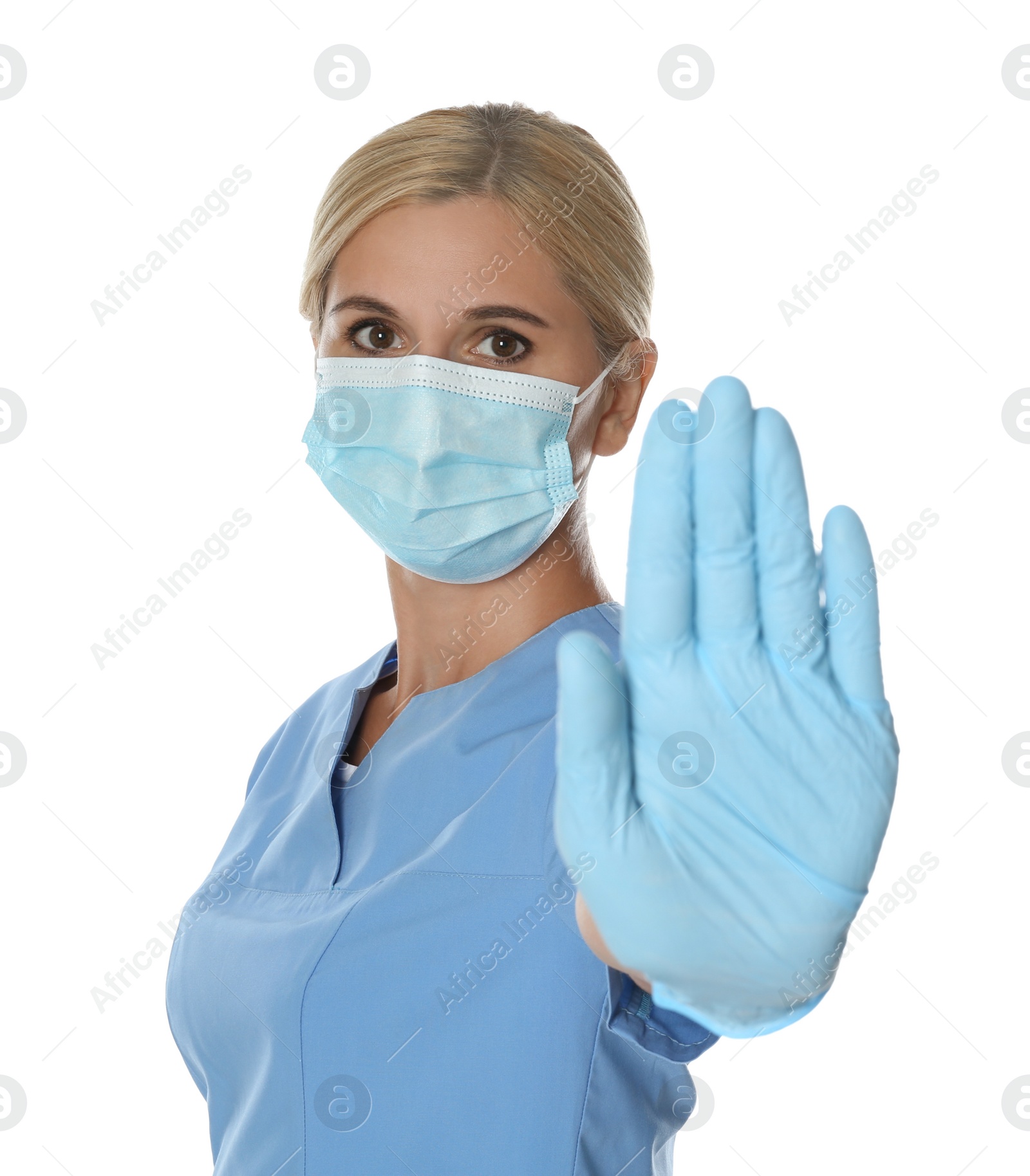 Photo of Doctor in protective mask showing stop gesture on white background. Prevent spreading of coronavirus