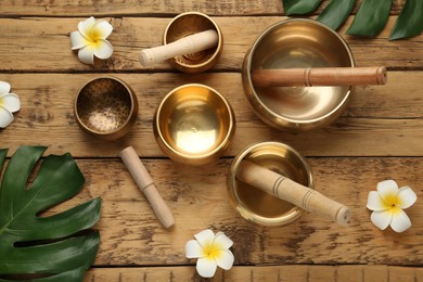 Photo of Flat lay composition with golden singing bowls on wooden table