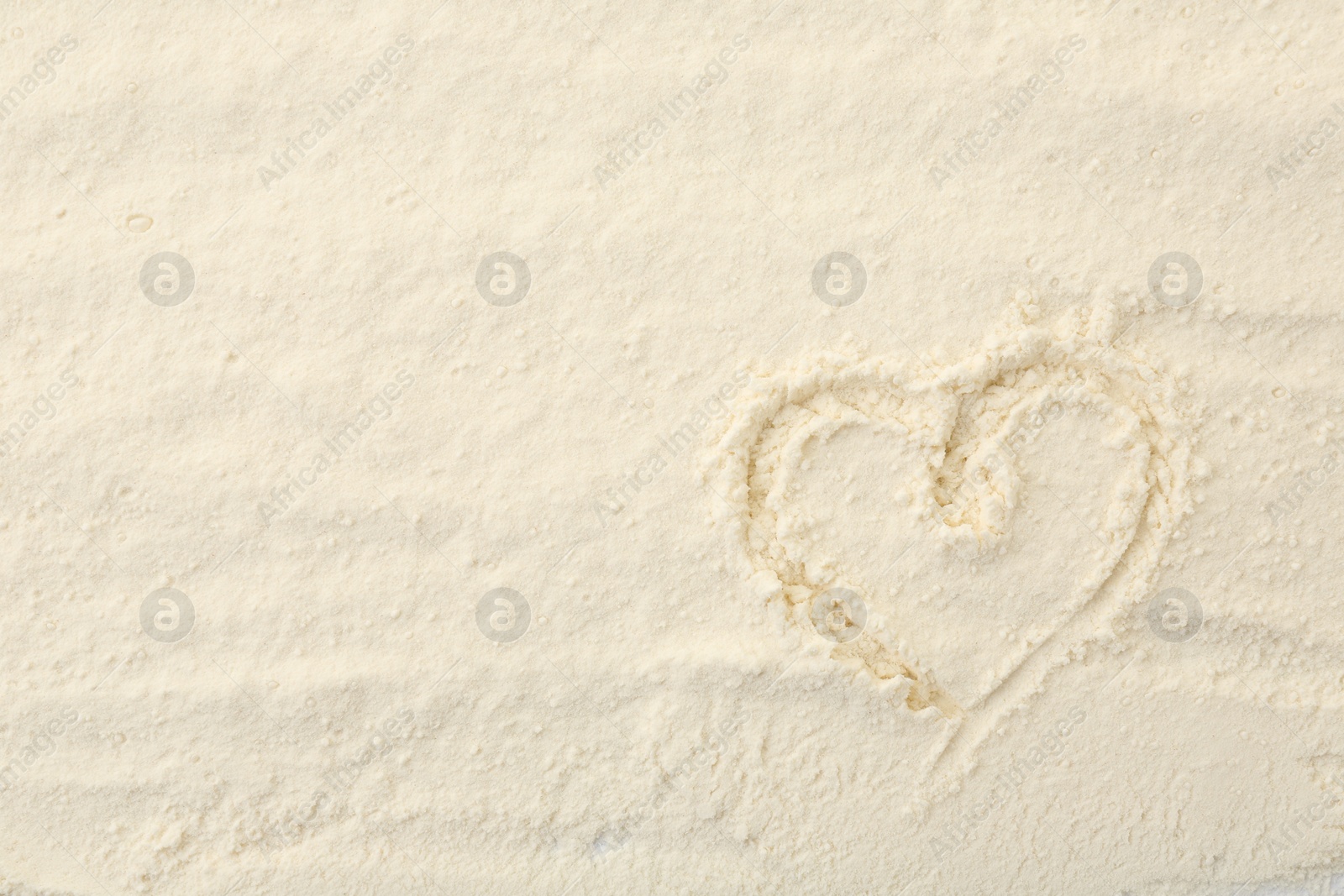 Photo of Heart drawn on baking powder, top view. Space for text