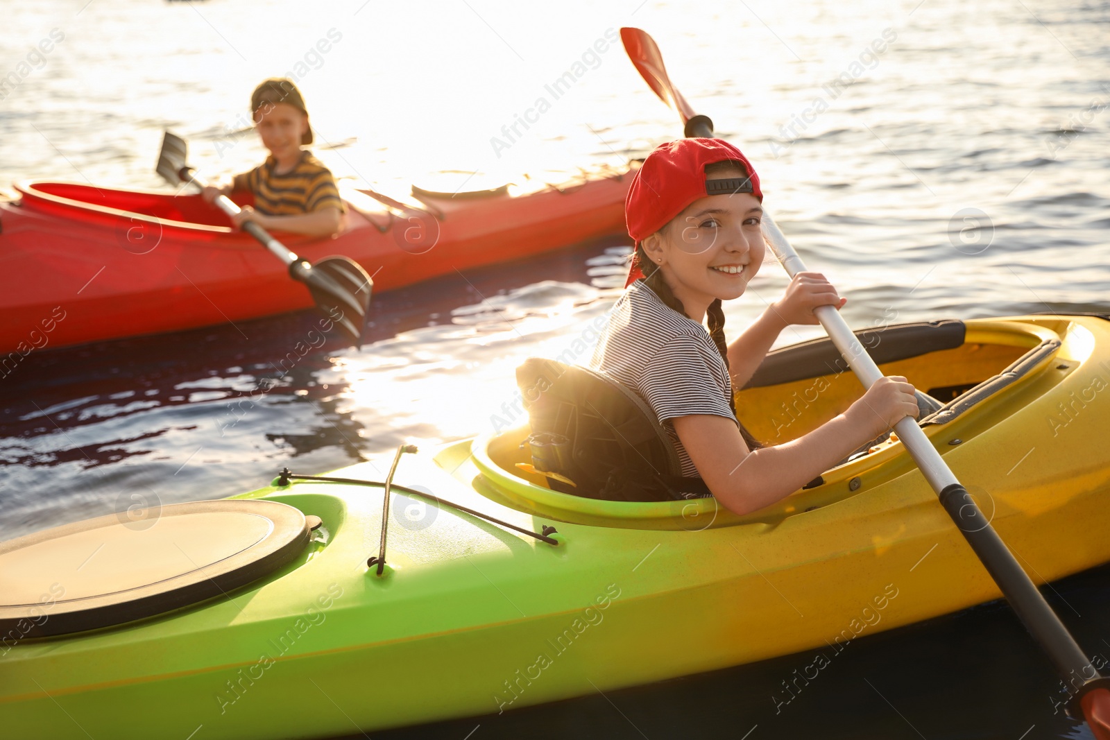 Photo of Little children kayaking on river. Summer camp activity