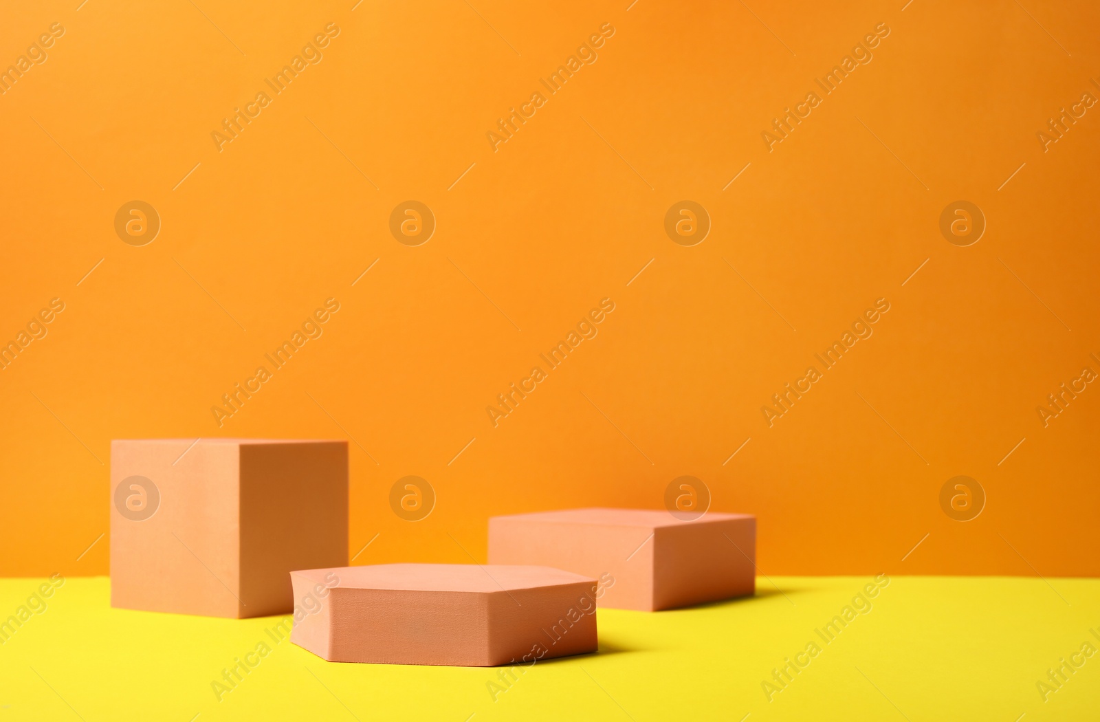 Photo of Geometric figures on orange background, space for text. Stylish presentation for product