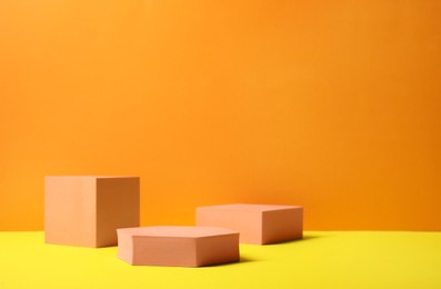 Photo of Geometric figures on orange background, space for text. Stylish presentation for product